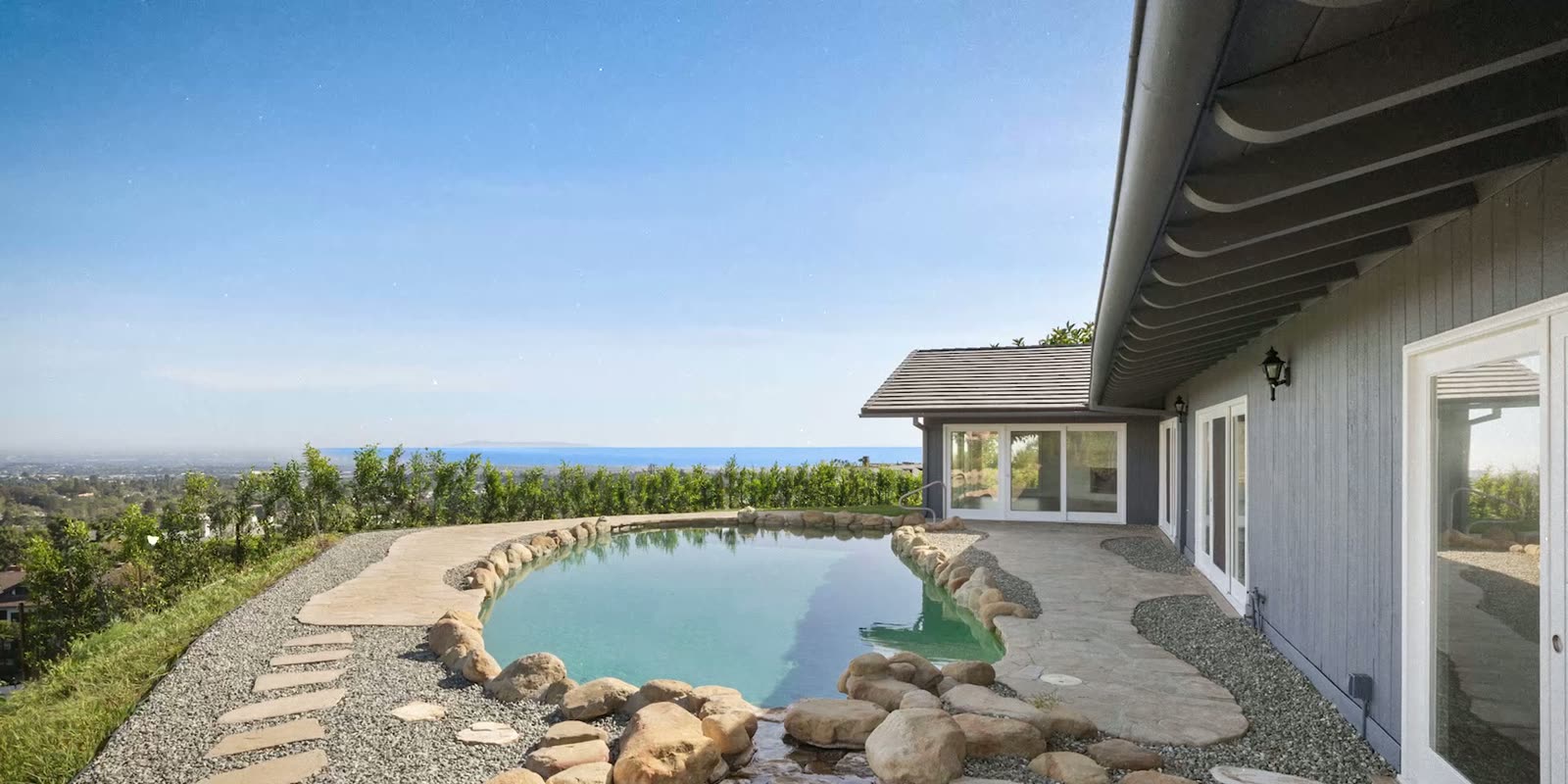The ranch house's kidney-shaped pool and spa seen from the patio