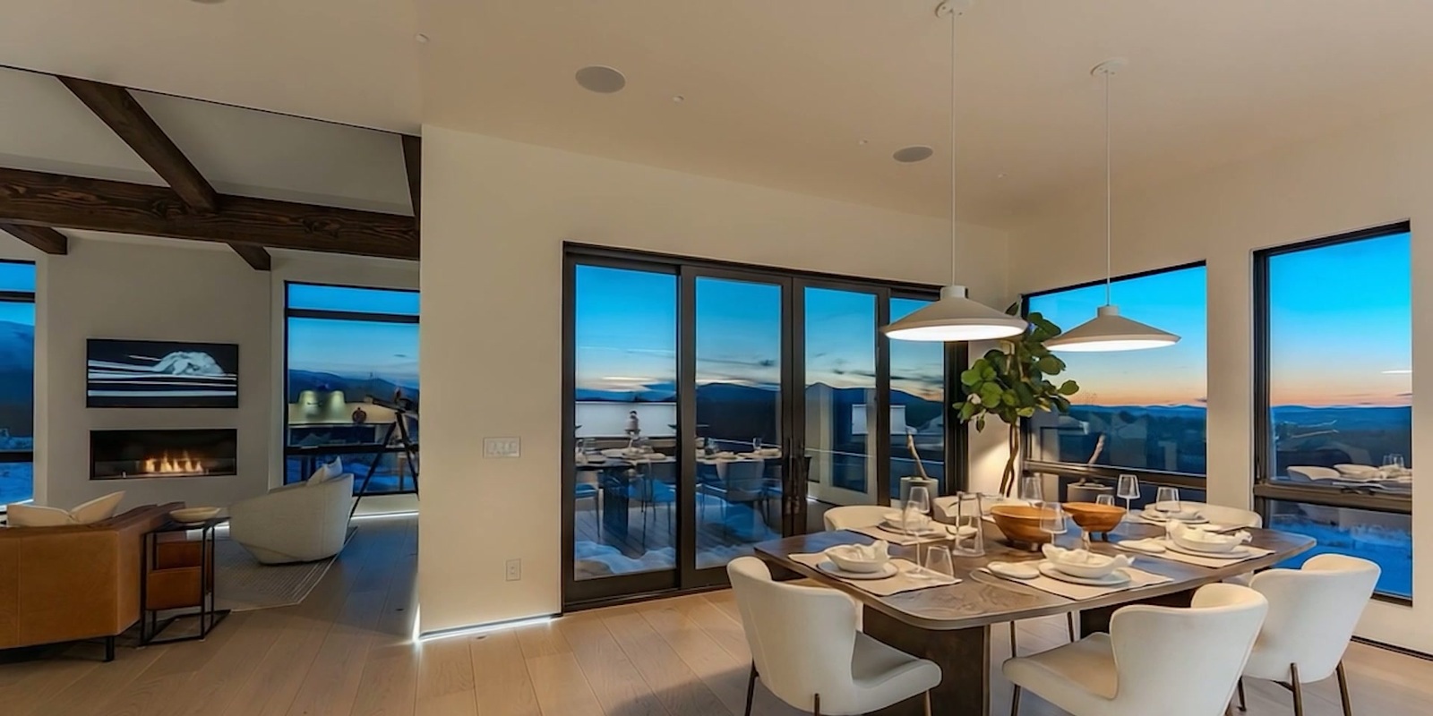An AI visualization of a dining room set for a meal, with broad windows looking toward the mountains