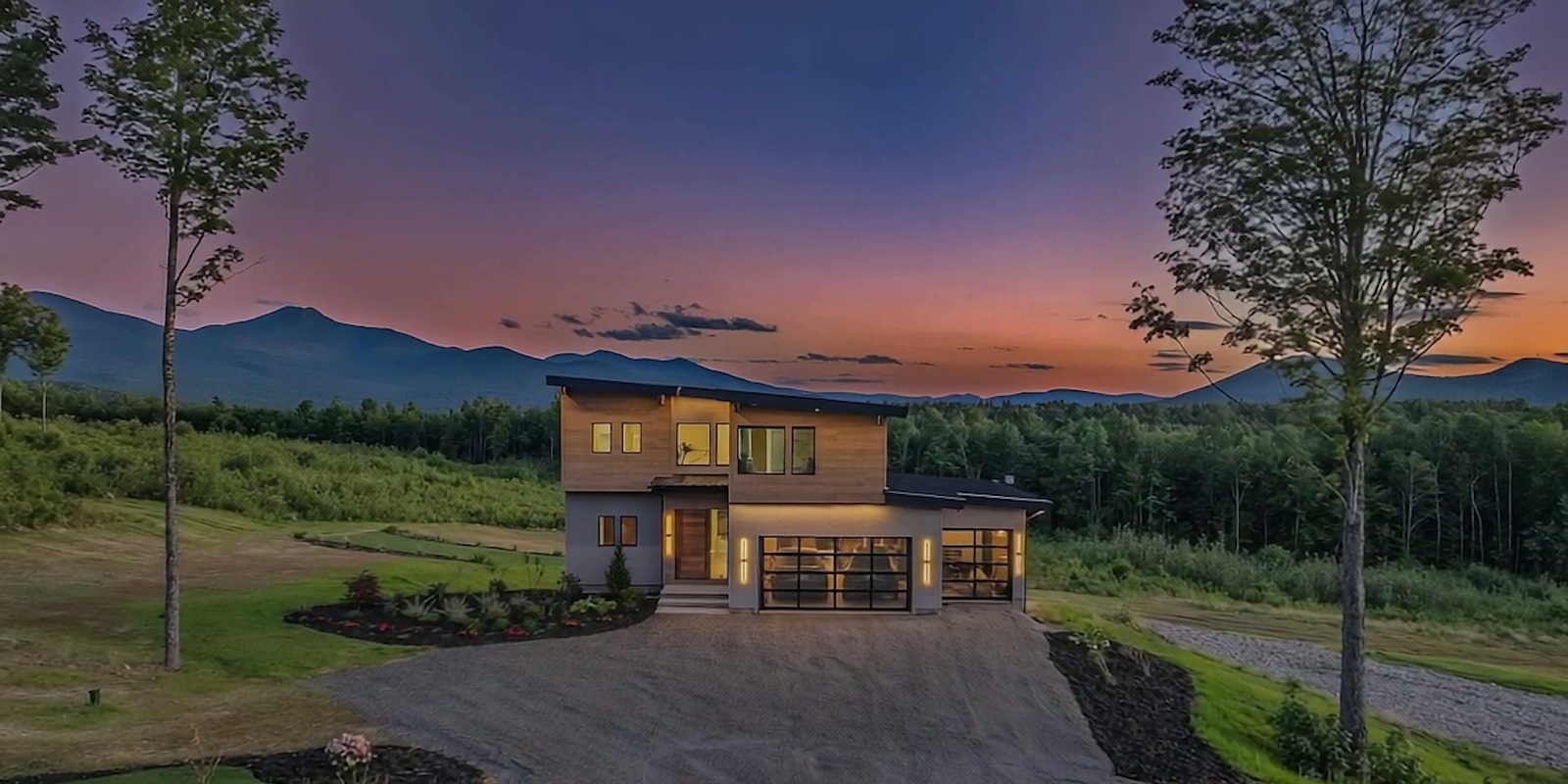 An AI visualization of a modern home beneath a mountain skyline at dusk